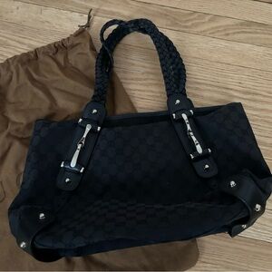 This is an authentic GUCCI Monogram
Medium Pelham Shoulder Bag in black.